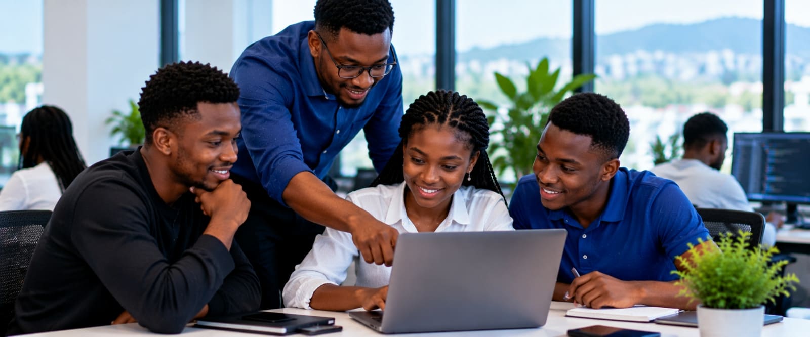 Un formateur JSP travaille avec un groupe d’apprenants autour d’un ordinateur portable