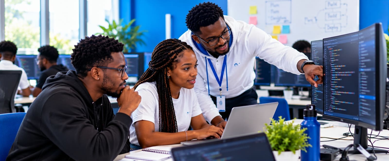 Des apprenants en génie logiciel programment en binôme avec leur formateur