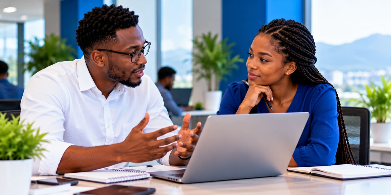 Two partners discussing a project at a laptop