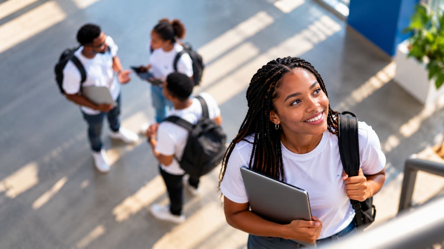 A JSP learner smiling in a sunlit campus atrium